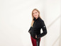 Une femme porte une veste noire Equisport avec un legging rouge.