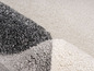 Détail d'un tapis gris, blanc et gris clair.
