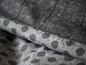 Gros plan d'un tissu noir à pois blancs.