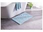 Un tapis de bain bleu dans une salle de bain avec une baignoire