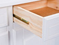 Une commode blanche avec un tiroir ouvert qui révèle un intérieur en bois.