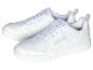 Une paire de baskets blanches avec des lacets blancs, posées sur un fond blanc.