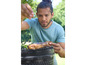 Un homme sale un steak sur le barbecue.