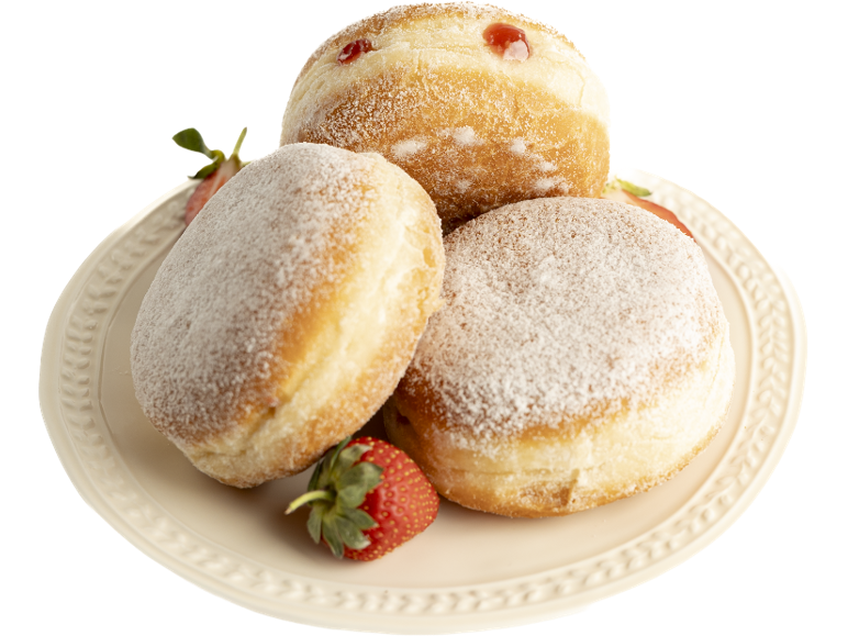 Beignets moelleux saupoudrés de sucre glace et de confiture, avec des fraises fraîches sur un plat.
