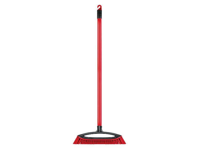 Un balai rouge à long manche.