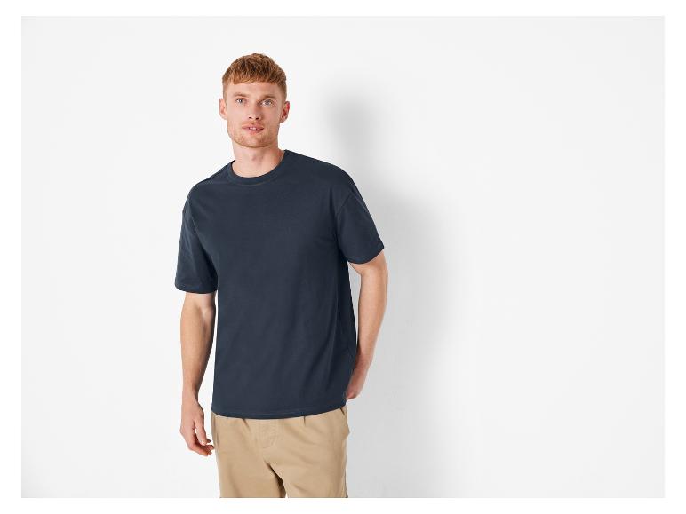 T-shirt foncé et pantalon beige pour homme.