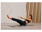 Une femme fait des exercices abdominaux sur un tapis de yoga avec un disque d'équilibre.