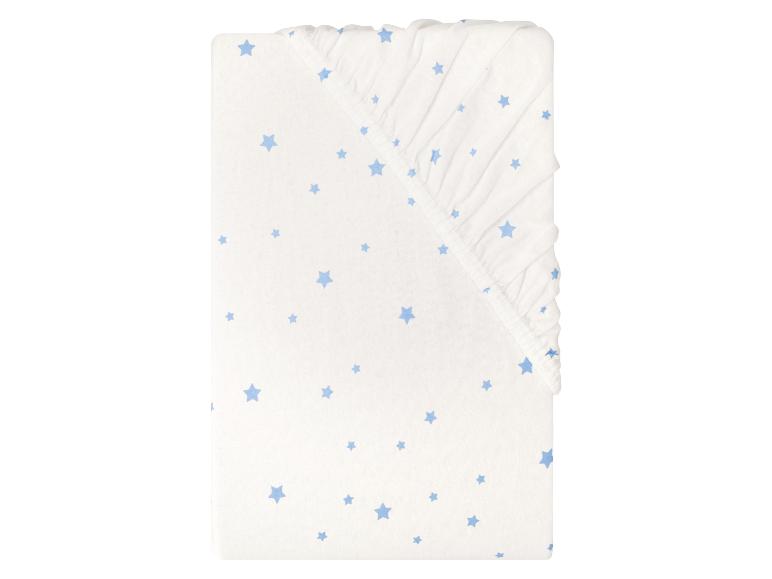 Drap-housse blanc pour bébé avec motif étoiles bleues.