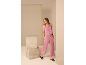 Femme portant un gilet en lin rose et un pantalon large assorti.