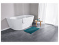 Une baignoire blanche, un sol gris foncé et un tapis de bain turquoise.