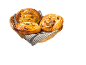 Panier en osier avec trois escargots aux raisins dorés sur un tissu rayé.
