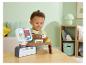 Un tout-petit joue avec une caisse enregistreuse Fisher-Price avec scanner et aliments.