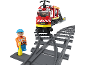 Train jouet sur des rails avec un aiguillage et une figurine d'ouvrier.