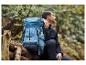 Un homme avec un sac à dos Crivit bleu dans une forêt