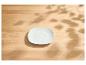 Soucoupe blanche carrée sur une table en bois clair avec des ombres de feuilles.