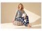 Femme en haut de pyjama gris et pantalon à carreaux, texte 'LETS STAY IN BED'.