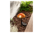 Un luminaire de jardin solaire en forme de champignon avec un abat-jour en verre orange.