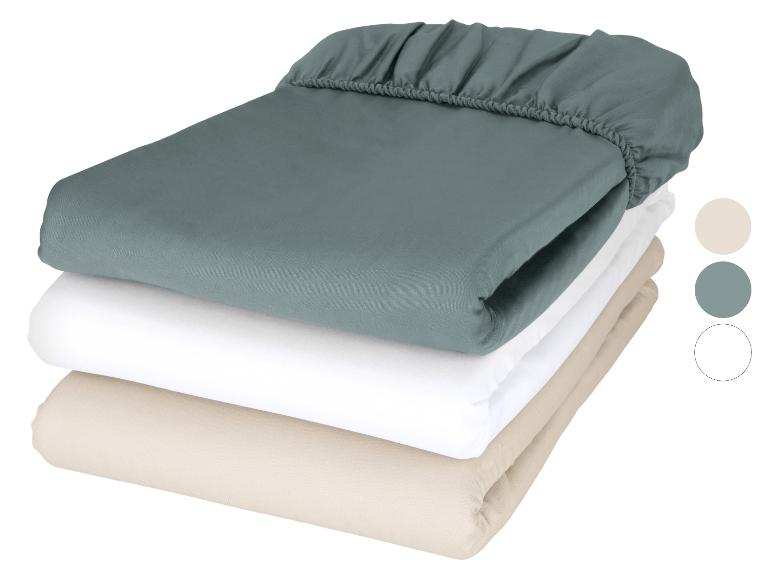 Pile de draps-housses en sarcelle, blanc et beige avec des échantillons de couleurs.