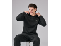 Homme en sweat à capuche et pantalon de survêtement noirs, assis sur un tabouret.