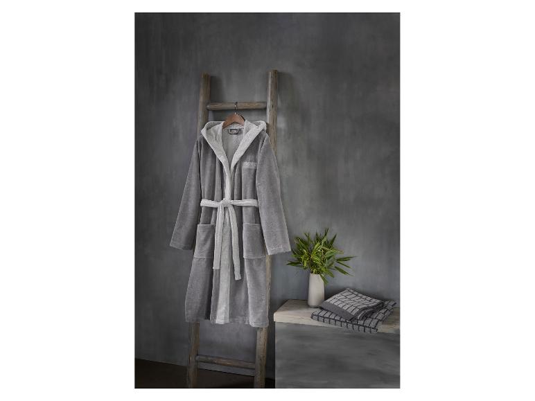 Peignoir gris sur échelle en bois, bambou et serviettes à carreaux sur banc en bois.