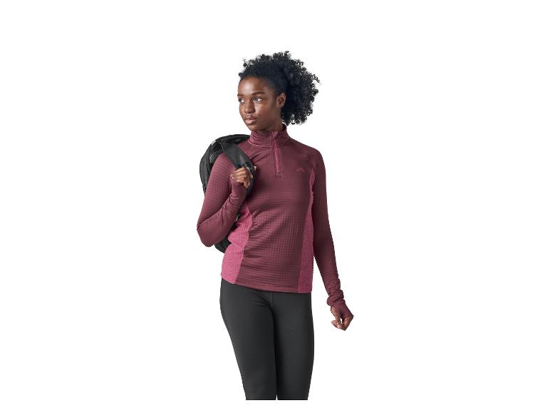 Femme en haut de sport et legging noir, avec un sac à dos sur l'épaule.