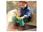 Enfant jouant avec du sable dans un bac à sable en bois avec bancs.