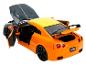 Une voiture jouet Nissan GT-R orange avec les portes et le coffre ouverts.