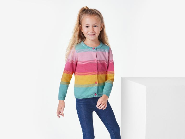 Une fille porte un pull rayé et un jean bleu.