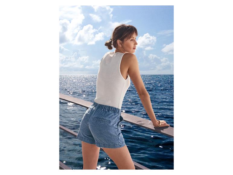 Femme en short en jean ESMARA® sur un bateau avec vue sur la mer.