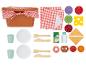 Un panier de pique-nique avec une nappe à carreaux rouges et blancs, des assiettes, des tasses, des couverts et divers aliments jouets.