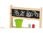 Un support de jeu en bois avec un tableau noir, un pot vert et des crayons rouges et verts.