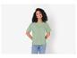 Une femme portant un t-shirt vert et un jean bleu.