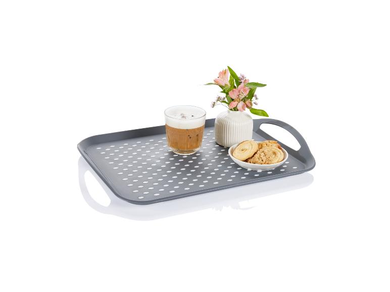 Plateau à pois gris avec café, biscuits et fleurs.