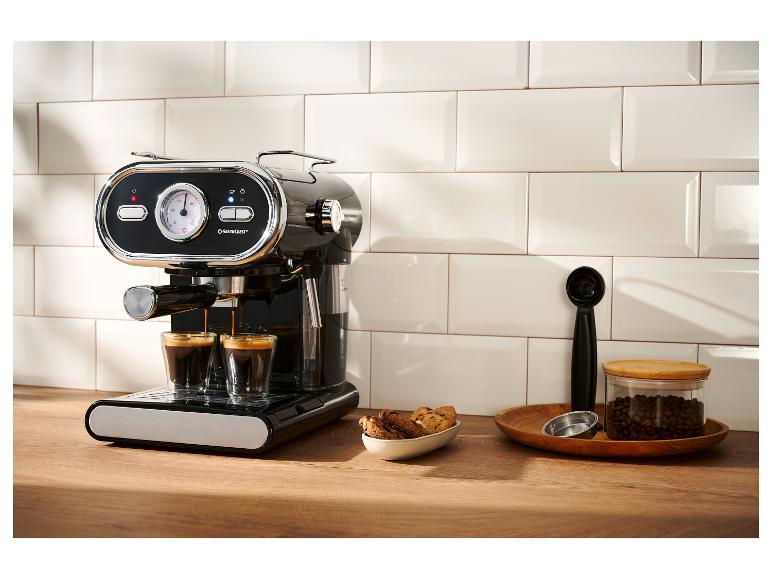 Machine à expresso noire préparant deux cafés, avec des biscuits et des grains de café.
