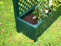 Jardinière verte avec treillis pour plantes grimpantes dans le jardin.