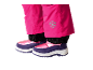Pantalon de neige rose pour enfants avec emblème flocon de neige et bottes d'hiver violettes et roses.