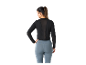 Une femme porte un haut de sport noir et un legging bleu.