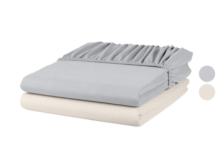 Draps housses pliés en gris et beige.