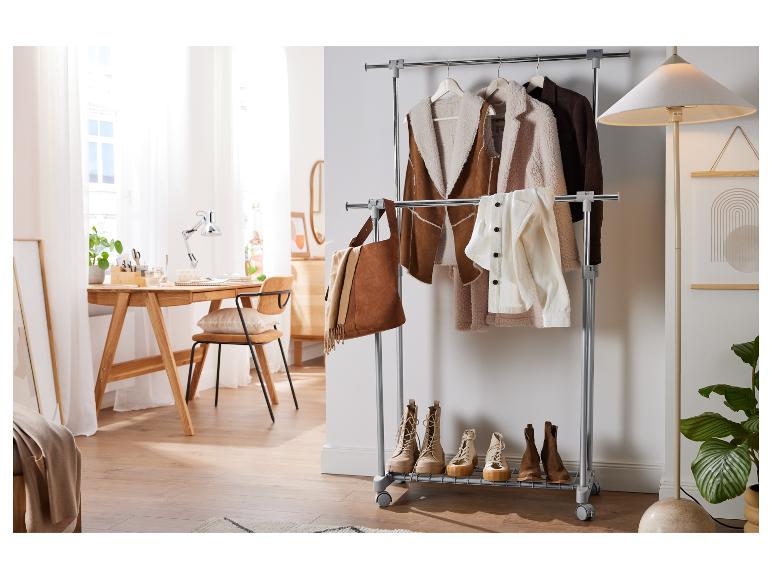 Un portant à vêtements avec un sac en cuir, des vêtements et des chaussures.