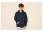 Jeune homme en sweat à capuche bleu marine et jean clair.