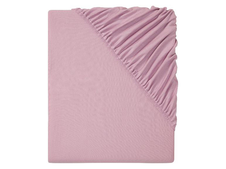 Drap-housse rose clair avec élastique.
