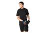 Homme en t-shirt noir, short et gants, tenant un casque de vélo.