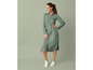 Une femme portant une robe verte et des baskets blanches.