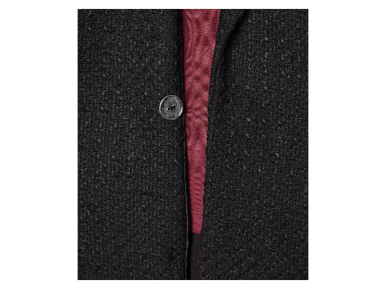 Détail d'une veste en maille noire avec un bouton et une chemise marron.