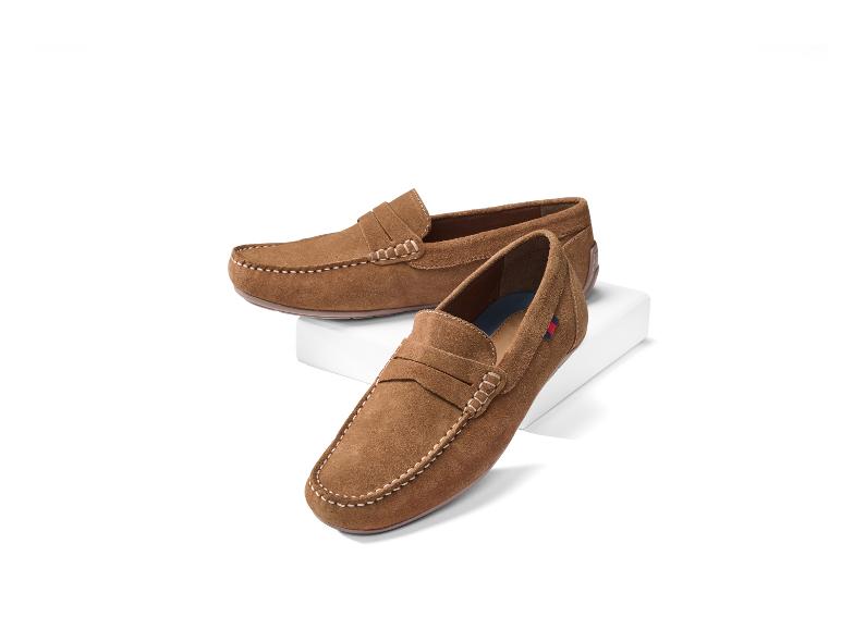 Paire de mocassins en daim marron pour hommes sur un présentoir blanc.