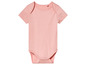 Un body bébé rose à manches courtes.