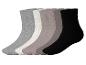 Cinq paires de chaussettes de différentes couleurs : gris, blanc cassé, beige, gris foncé et noir.