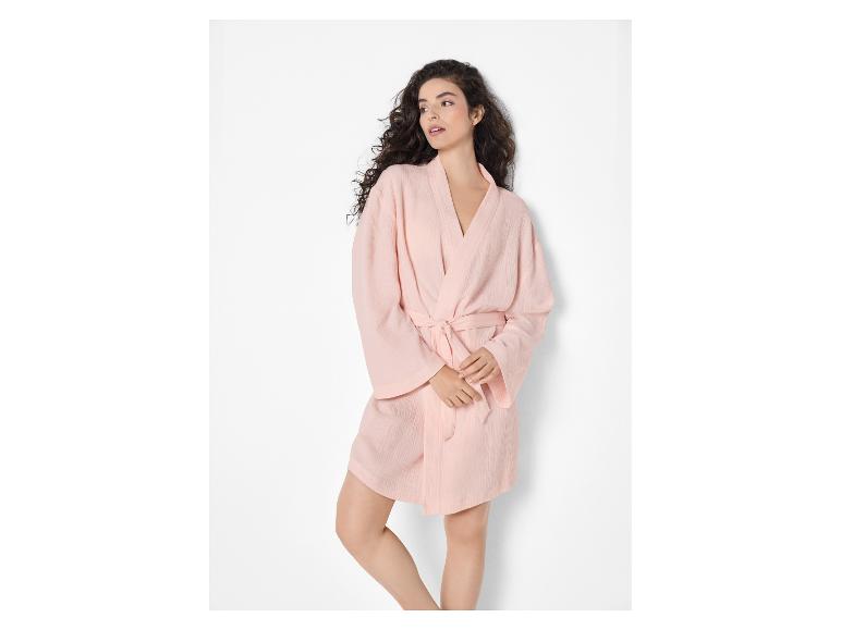 Femme en peignoir court rose clair avec ceinture à nouer.