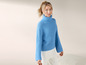 Une femme portant un pull bleu à col roulé.