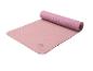 Tapis de yoga rose Crivit partiellement enroulé avec texture antidérapante.